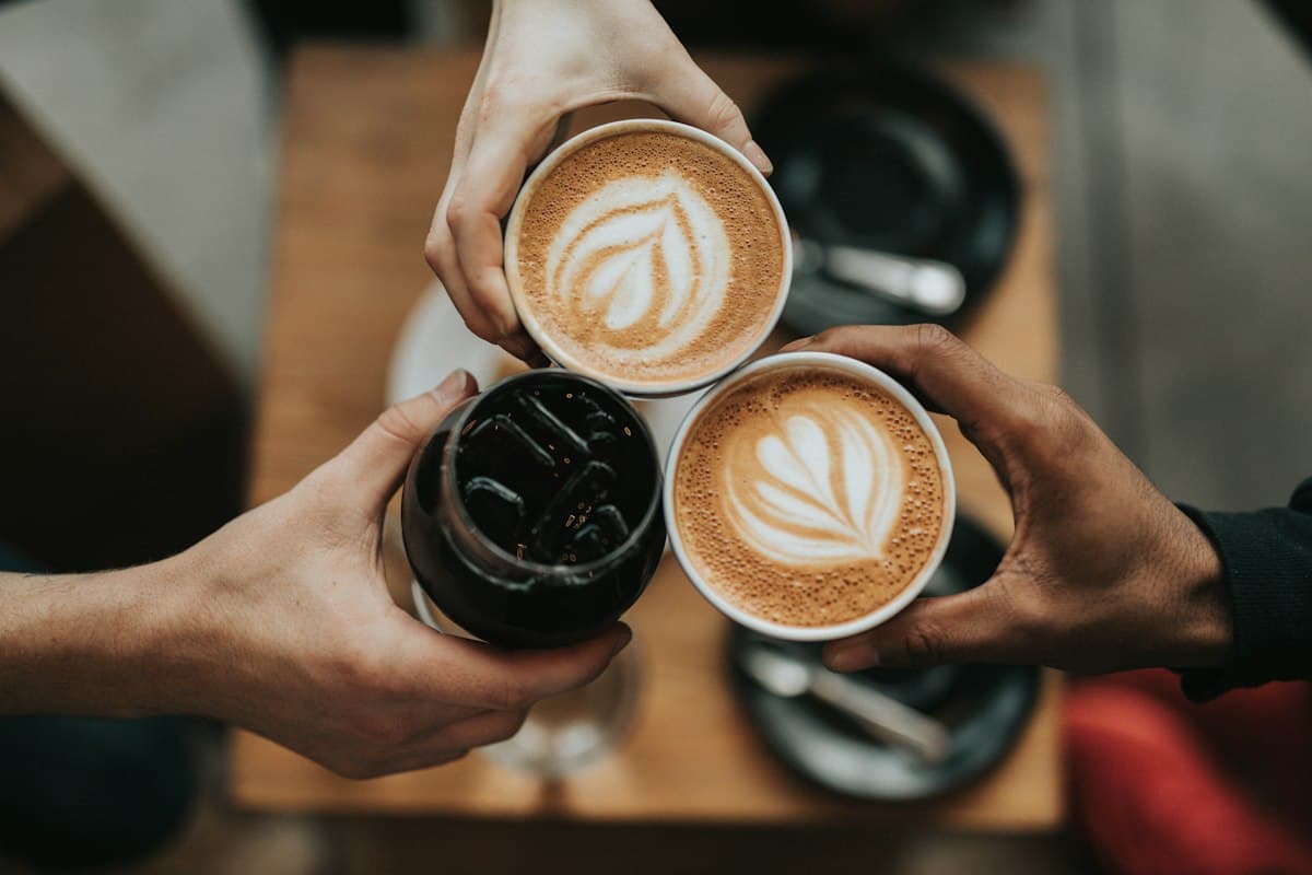 Latte with foam art in a white cup on a wooden table